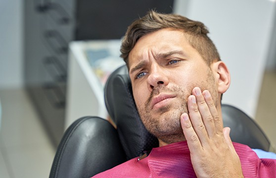 Patient in treatment chair struggling with toothache