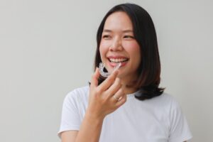 Woman smiling while putting in her SureSmile